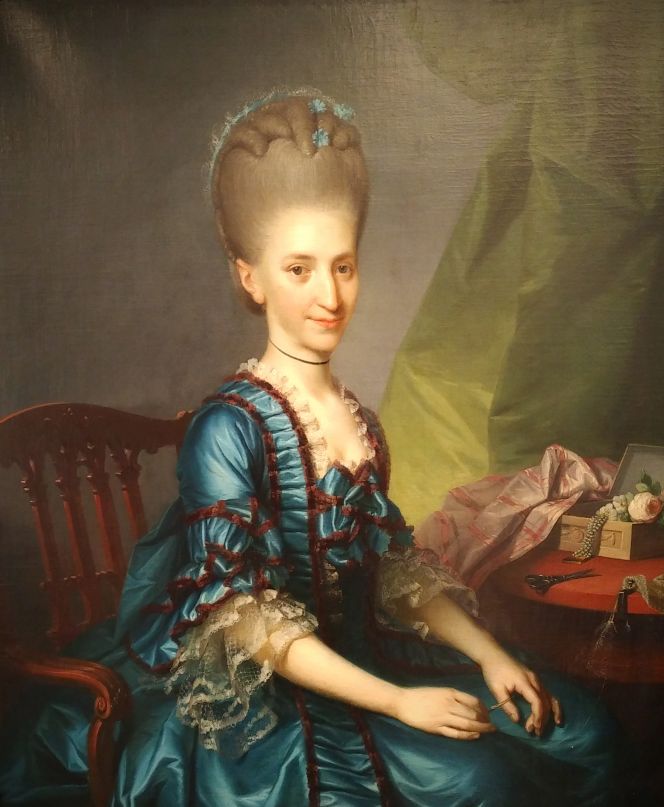 A portrait by the Danish artist Jens Juel (1745-1802) of an unknown fashionable young lady wearing a Robe à la Française of finest silk, in the early 1770s. Her ongoing handiwork – a netlike tulle – seems to imply that she previously had made the three-layered lace ruffles for her elbow length sleeves. Such a fine net ground was made with the long needle in her hand by making a loop and twisting the thread repeatedly from side to side, assisted by a pair of scissors and a hook fastened on the table. When the net had reached the required length, it was preferably stretched in a frame and added with needle-work of a chosen design. (Private Art Collection, København, Denmark). Photo: Viveka Hansen, The IK Foundation.