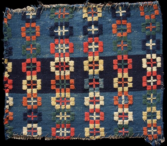 This colourful example was woven during the first half of the 19th century on a linen warp and natural dyed woollen weft. Today, only a fragment is extant, 47 x 40 cm, of a once much larger textile, probably a decorative bedcover. The shuttle was used for the indigo/woad blue main weft, whilst the brocading weft was inserted by hand during weaving due to the use of several colours, including red, blue, green, white and yellow. | Färs or Vemmenhög districts, Skåne province, Southernmost Sweden. (Courtesy: The Nordic Museum, Stockholm. NM.0134537. DigitaltMuseum).