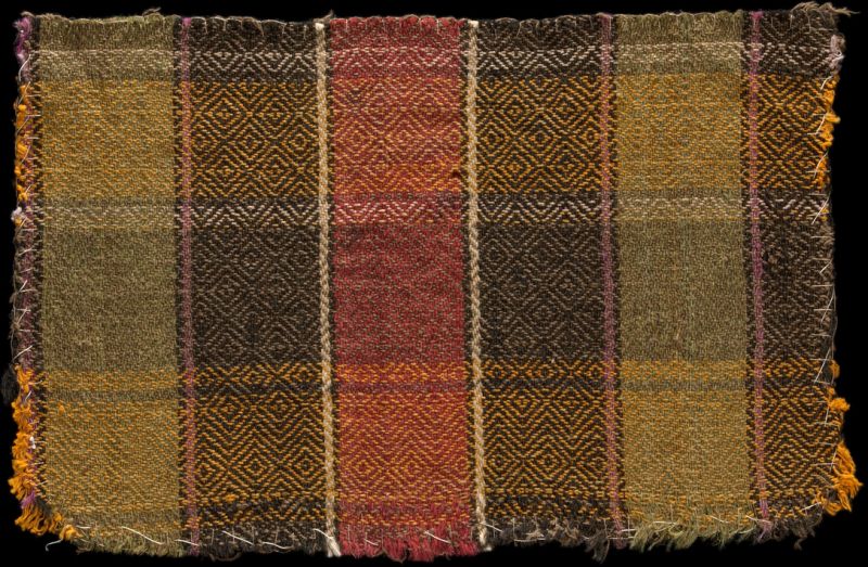 This carefully constructed handwoven composition in “gåsögon”, circa 1860-1900, is believed to be a remnant of a bedcover, originating from Äppelbo parish, Dalarna province, in central Sweden. The intense orange colour is probably chemically dyed, and the use of machine-spun cotton threads indicates that the bedcover was woven after the year 1860. For the striped warp (horizontal in this picture), several colours of cotton yarn were used, while the weft includes hand-spun wool and cow hair, and the district white lines were woven with three spooled threads of white cotton yarn. In this twill variation, with its diagonal lines changing direction in both warp and weft, the typical diamond-shaped design is clearly visible in this textile. The uneven overcasting around the extant fabric sample was probably performed later.| Given as a gift to the Nordic Museum in 1926. (Courtesy: The Nordic Museum, Stockholm. NM.0157990. DigitaltMuseum).
