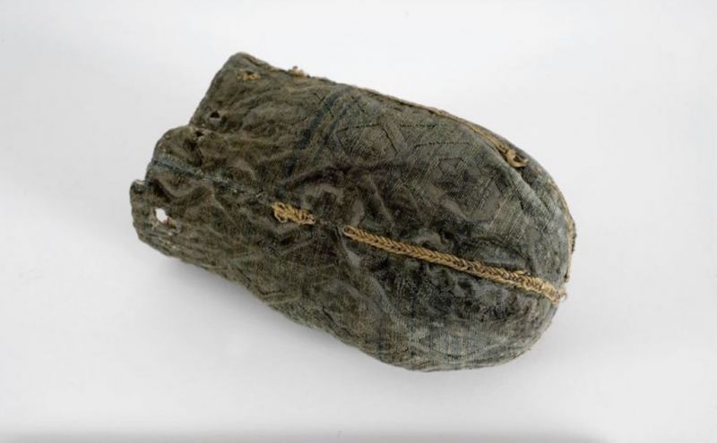 This well-preserved purse was used for safe-keeping of valuable seals by the carpenter’s guild in Malmö, 1602. The purse was made of an exquisite cut velvet on a satin ground, stitched together of four fabric pieces, whilst the seams are decorated with a fragmented chain stitch embroidery of metallic gold thread. The purse was probably made of leftover pieces from a garment or interior textile. Holes were placed with regular intervals to pull a string/cord through – not preserved today – and the purse was lined with an unbleached linen. (Courtesy of: Malmö Museum, MM000139:002, Creative Commons).
