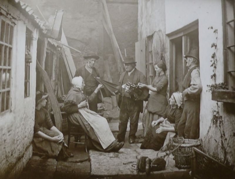 “The Umbrella Seller” from the 1870s. This staged photograph depicts one of the yards in the eastern part of old Whitby, if the group of people were just admiring the umbrellas or someone actually made a purchase from the travelling salesman is hard to know. (Photo: Frank Meadow Sutcliffe).