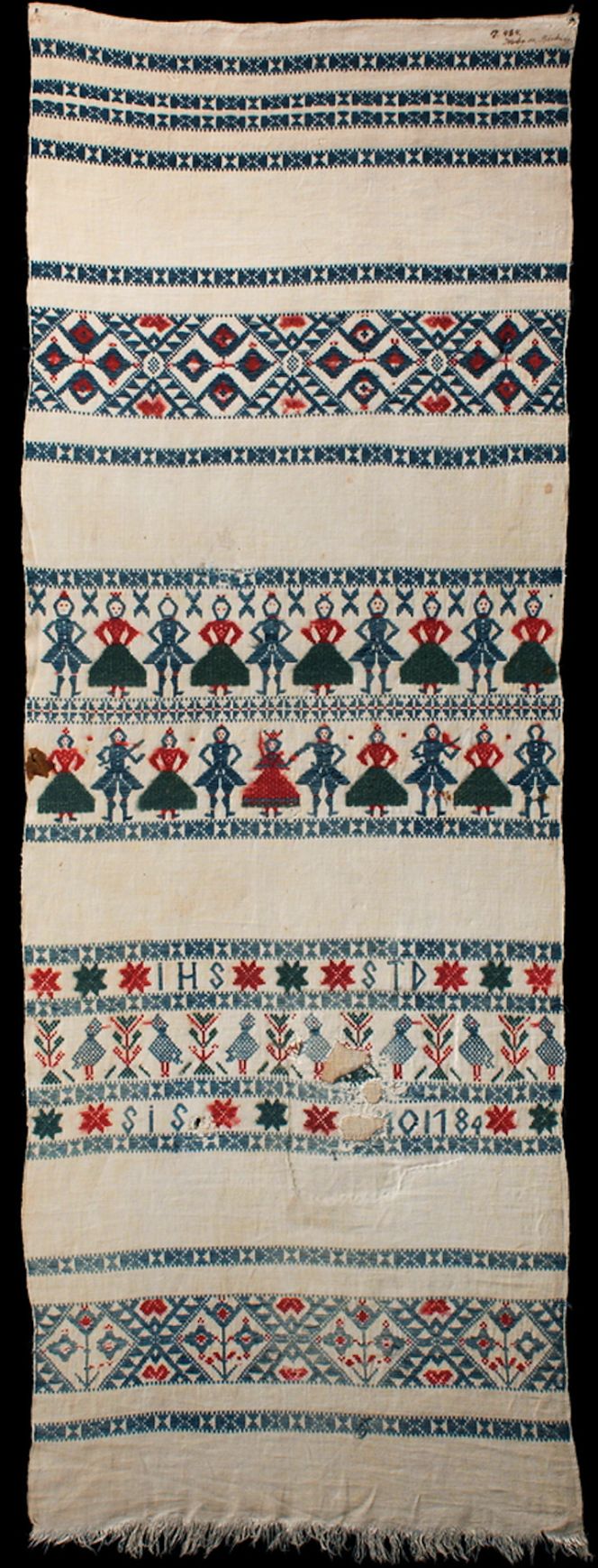 This vertically hanging linen cloth is typical in style for the decades around 1800; it was made/dated ‘1784’. The fabric was handwoven with an unbleached linen warp, with the same linen thread used for the shuttled ground weft. Various intense colours of woollen yarns were chosen for the decorative motif borders – woven in the traditional techniques opphämta and krabbasnår. Bräkne district, Blekinge province. (Courtesy: Nordic Museum, Stockholm, Sweden. NM.0017484. DigitaltMuseum).