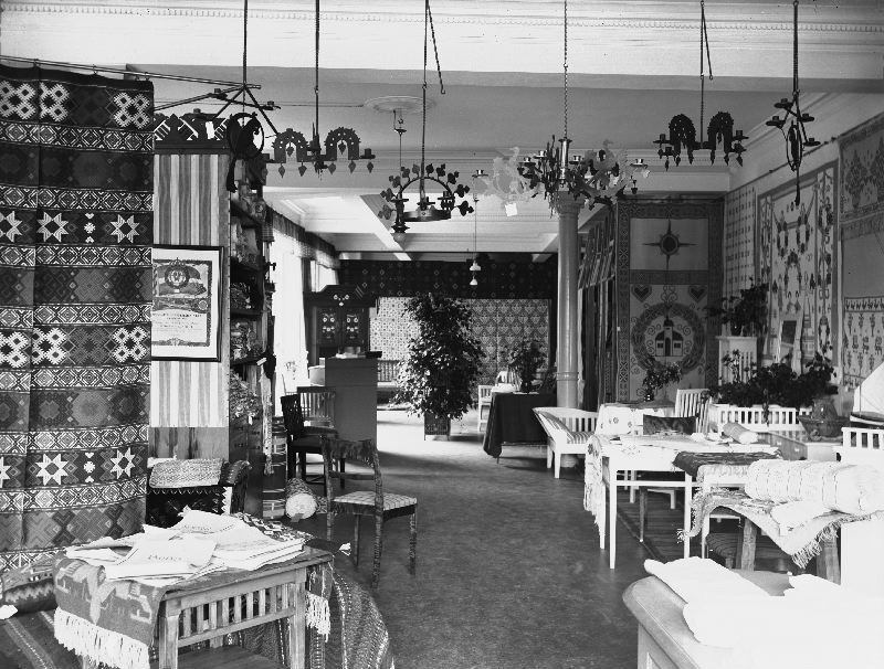 The interior of the same shop in 1908 gives a glimpse of the display, including textile furnishing – possible to buy ready made or to weave/embroider oneself after motifs and techniques with traditions stretching 100 years or more from the local area – and other handicraft objects. (Courtesy of: Malmö Museum, No: EF 000228. Photo: by Viktor Roikjer).