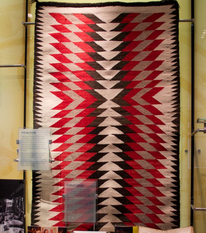 The Museum exhibition also describes that the Navajo have had a long tradition of using natural dyes, but with the introduction of synthetic substances a gradual change gave way to greater variations and the possibility to buy synthetically dyed yarn. Noted as follows; ‘The brightly colored rugs and other textiles woven by the Navajo during the 1860s and 1870s became known as “Germantowns,” after Germantown, Pennsylvania, home to the mills that produced the synthetically dyed yarn. This lightweight, brilliantly colored yarn in shades of red, blue, green, purple, black, and yellow never before available to the Navajos enabled weavers to create new, intricate designs of dazzling complexity.’ (Exhibition “Making Modernity”). Photo: The IK Foundation, London (2014).