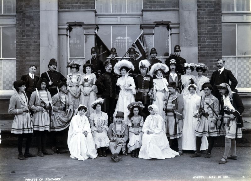 The theatre company at the Pavilion is dated May 26 1904. The piece performed was the comic opera ‘The Pirates of Penzance’. The actors are dressed as pirates mixed with policemen, ladies in Edwardian dresses and hats, other ladies in nightdresses, and men in uniform. An unusual Whitby photograph shows that a theatrical performance of the time used a mixture of contemporary clothes and specially made theatrical costumes. (Courtesy: Whitby Museum…, Photographic Collection, E 857).