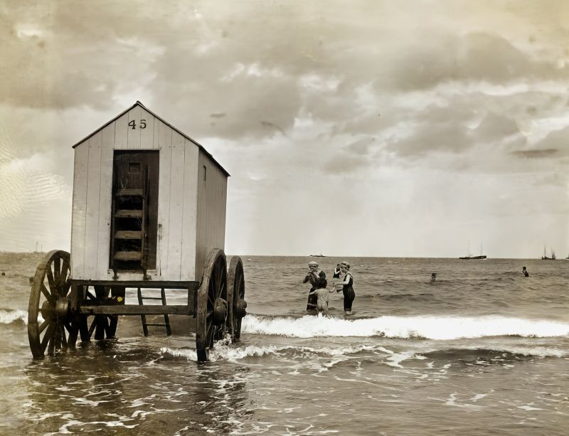 This photograph of bathing hut ’45’ also depicts women, men and children in bathing costumes at Whitby beach, circa 1900-1910. (Courtesy: Whitby Museum, Photographic Collection, C533, part of photo. Unknown photographer).