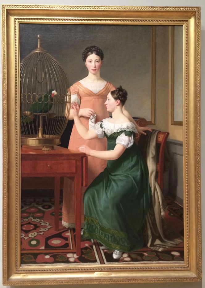 While this oil on canvas by the Danish artist Christoffer Wilhelm Eckersberg (1783-1853), representing ‘Mendel Levin Nathanson’s Elder Daughters, Bella and Hanna’ in 1820. Eckersberg was regarded as the master of portraits among other genres and also seen as the artist who introduced the period in art known as the Danish Golden Age. To portray siblings, draped or folded textiles, small-sized knitting projects, distraction or concentration as well as a melancholic impression in home interiors were common in the Romantic Era. This painting includes all these features. The handicraft is visible via the standing girl’s ongoing knitting of a white silk or cotton sock, simultaneously as the choice of matching colours was intended to be the main focus – the high standard of living was visualised as stylish and perfect. Their colourful clothing either stand out from the background or harmonised with other depicted objects – particularly striking is the carefully chosen intense green colour of the dress, the caged parrot as well as on leaf work on the ornamented woollen carpet. (Collection: Statens Museum for Kunst, København, Denmark. No: KMS3498. On display in 2019). Photo: Viveka Hansen, The IK Foundation.