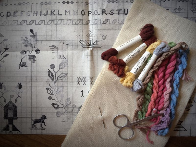 Surplus linen and cotton yarn together with the sketch for the reconstruction of the sampler in cross stitch, still preserved among my handicraft material since 1981! Notice the rather subdued colours, which even if chemically dyed were aiming to reconstruct the impression of a sampler prior to the 1850s – at a time when natural dyes only were in use. The motifs and design for this sampler had been copied and to some extent adapted after an old (c.1780s-1830s) sampler by the Handicraft Organisation of Malmö in 1958. To my knowledge, it is unknown where this original embroidery is kept today. (Private ownership). Photo Viveka Hansen, The IK Foundation.