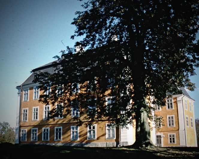 A very detailed Inventory in the year 1758 of Christinehof manor house in southernmost Sweden – a property owned by the Piper family since it was built around 1740 – did however not mention worktables used for embroidery or other textile techniques. The lack of sewing-tables in this inventory, may point to that other activities were preferred during the warm season, whilst the family stayed at this estate during the summer and early autumn months only. Or that the lady of the house and her daughter were not keen on handicraft or that other tables or portable work-boxes were in use, which may have been placed in the shade of a large tree in the garden. | The façade of the three-storey manor house was renovated in 1993 and restored to its original dark yellow colour. (Photo: The IK Foundation, London in 1994).