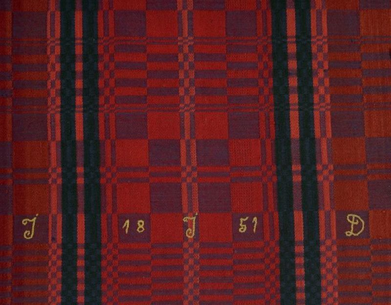 Despite the increasing textile industry with machine woven qualities, the hand weaving continued side by side during many years in the area, though with decreasing importance. This colourful bedcover of cotton warp and woollen weft is one evident example. The interior textile was produced in a home environment and clearly marked “1851” and the initials “JJD” in chain-stitch with silk thread. The unknown female weaver lived in the then rural area Östra Skrävlinge, which today is part of Malmö. (Courtesy of: Malmö Museum, No: MM 003638, detail of bedcover, 178cm x 134 cm).