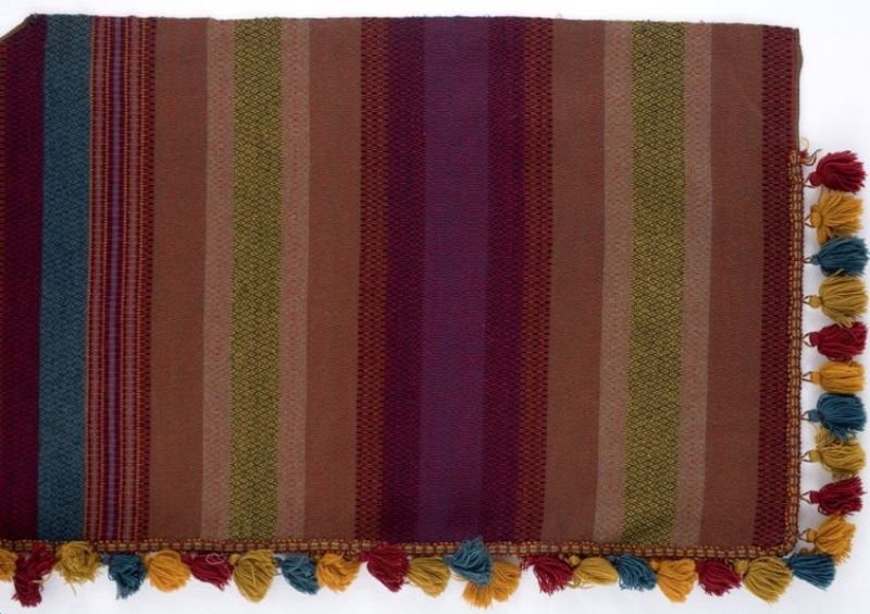 One of a pair of curtains dated 1888; hand-woven with cotton warp and woollen weft in strong synthetic colours. The designer is unknown, but the fabric in “rosepath” was strongly inspired by bench covers and cushions in technique/design/motifs from rural farming communities pre-1850s. Furthermore these decorative curtains were used in a bourgeois Malmö apartment at Östergatan in the late 19th century – as part of the interior design of a family’s dining-room, possibly purchased in a shop or ordered to fit this particular room. (Courtesy of: Malmö Museum, No: MM 042280:009).