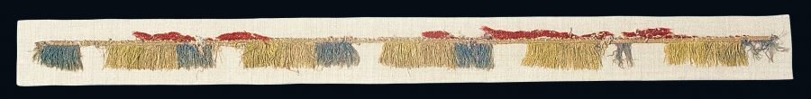 A tablet-woven silk ribbon with fringe in red, white, yellow and green/today faded to blue and metallic thread/gold. The work is dated to the late Medieval period. Photo: The IK Foundation, London.