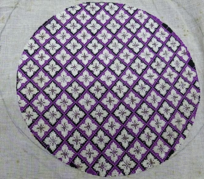 Another cross-stitch and bead embroidery was done in the 1860s-1880s. The embroiderer has made use of aniline on wool in a variety of shades of mauve and black, using a strictly repetitive design finished with a large number of beads, but it was never mounted. Judging from this category of embroideries in the Whitby Museum collection, the likelihood seems to have increased for the unfinished object to be preserved over time. Maybe, a handicraft piece like this had been put in a drawer to be finished at some other moment in time, which never happened, due to this it is still in perfect condition 150 years later. (Collection: Whitby Museum, Costume Collection, EMB 9). Photo: Viveka Hansen, The IK Foundation.