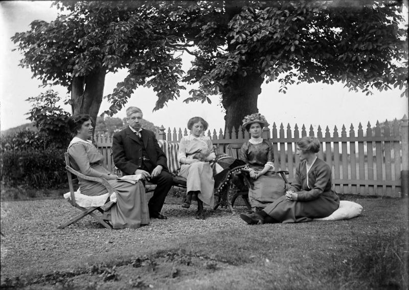 A final photograph dated to circa 1910 – of a family group at Stakesby in Whitby sitting in the garden on cushions – reveals several details of interest. In particular the centred lady who rests her arm on a large-sized cushion with a circle-shaped patchwork design made-up of various fabrics, together with darker coloured velvet for the corner sections and a striking decorative ball fringe. Even if upholstered furniture was preferred for chairs and sofas, it was a frequent habit of sitting on loose cushions, a usage that survived into the early 20th century also in well-off homes. Loose cushions were especially practical out of doors, as can be clearly seen in this picture of the Botham family, where various types of cushions have been taken out to enable them to sit in comfort in the garden. (Courtesy of: Whitby Museum, Photographic Collection, 2002/13.16. unknown photographer). 
