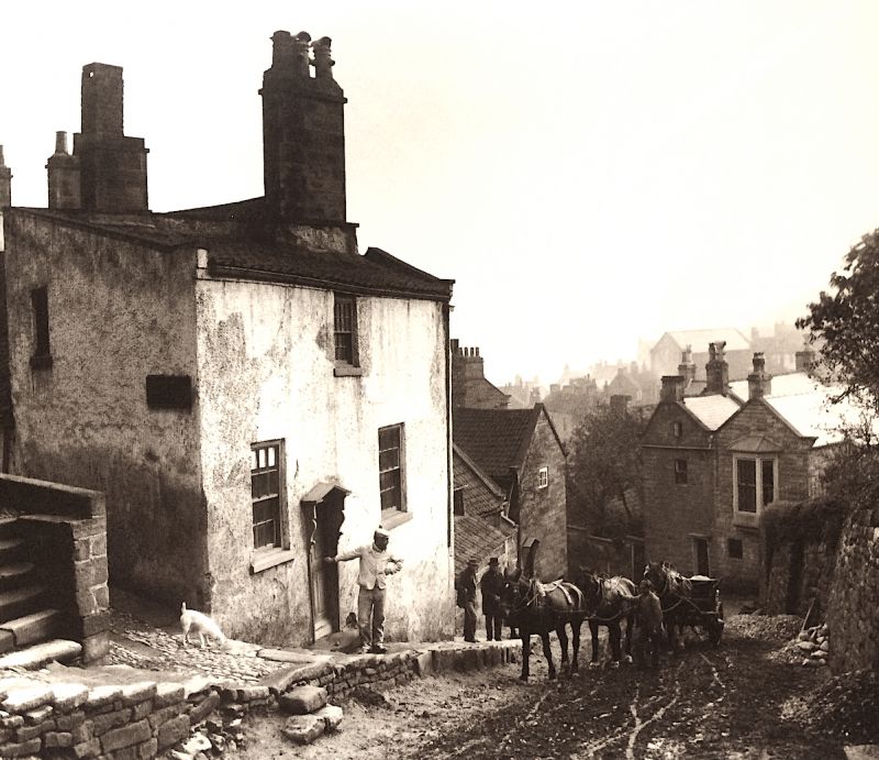 This photograph of the steep main road in the old parts of Robin Hood’s Bay was taken ca 15 years before the mentioned auction, leading up to where the railway line/station was opened first in 1885, which transported local inhabitants and tourists alike to Whitby or Scarborough. (Courtesy of: Whitby Museum, Photographic Collection. Photo: Frank Meadow Sutcliffe. C12).