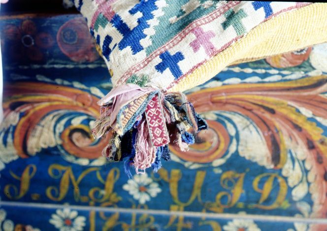 An unusually decorative corner tassel comprised of leftover cloth pieces and residue from paxxxttern-woven ribbons, on a cushion from south eastern Skåne. (Owner: Österlen museum). Photo: The IK Foundation, London.