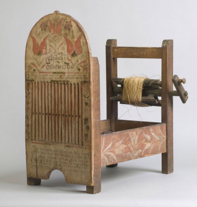 A tape loom with spools made in Milford Township, Pennsylvania. The lettering on the loom reads “Elizabeth Stauffer 1794” followed by a text in German mainly wishing her a good life. The German verse is further proof for this loom model’s origin, also to be compared with image (3) below showing historical reenactment weaving in the same type of loom in present-day Philadelphia. Courtesy of: Philadelphia Museum of Art, US.